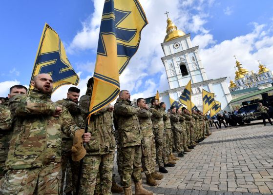 Azov Battalion members holding flags with the group's symbol